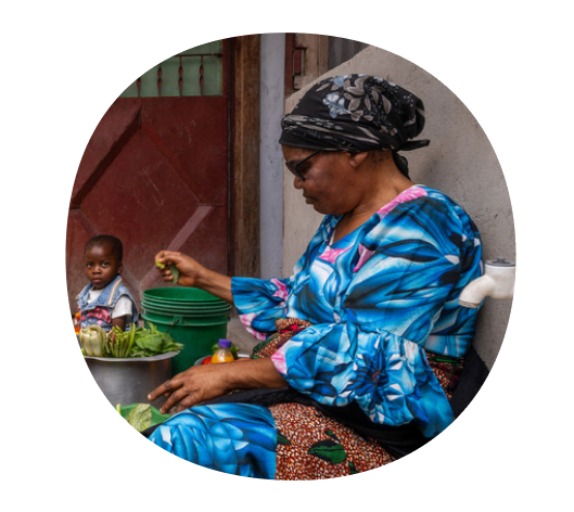 African woman sitting and making food.